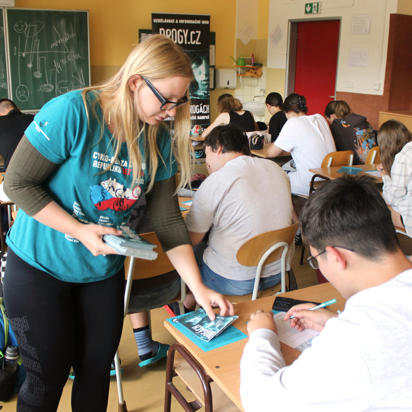 Drugsvrije Wereld-vrijwilligers delen de Feiten over Drugs-boekjes uit op een van de 61 scholen die ze dit jaar bezochten.