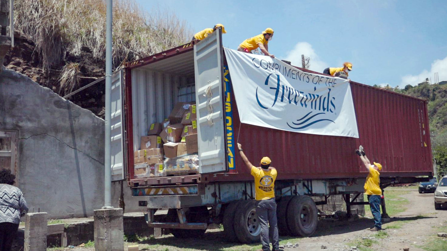 Ett VM-team lastar av en container med väsentliga förnödenheter, som  Freewinds skickade till ön med stöd från IAS.
