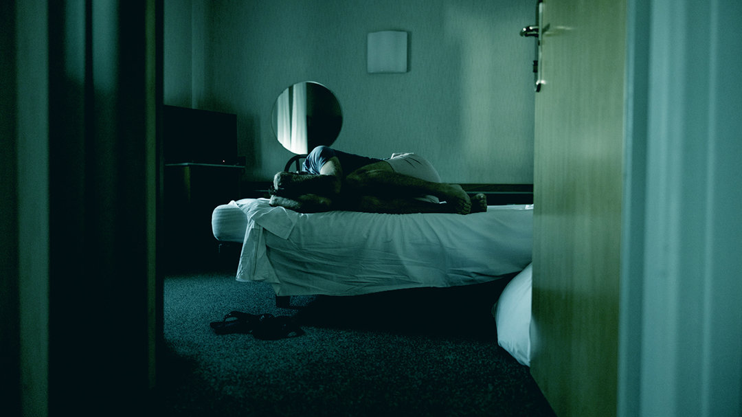 Man rolled-up on a bed