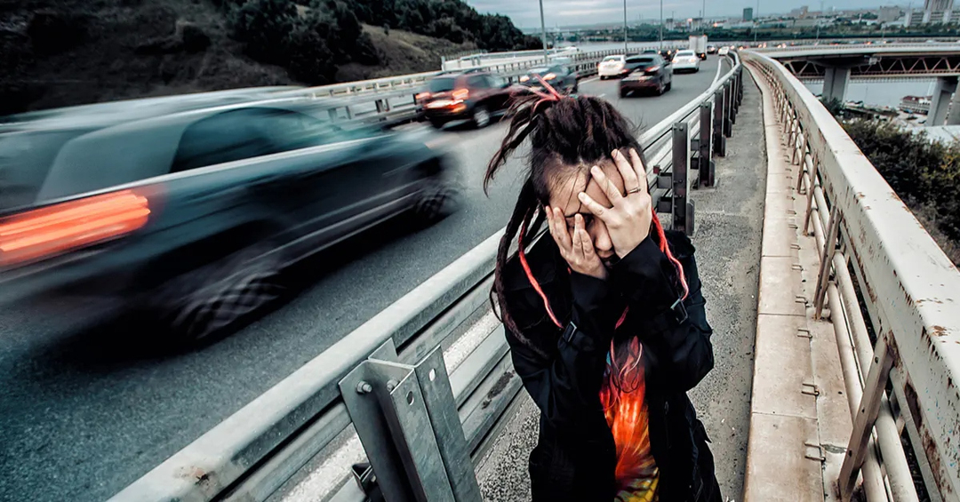 Person on a freeway holding their face in pain