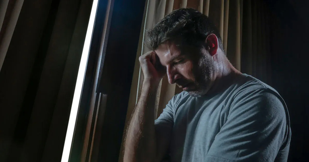 Man in a dark room in pain