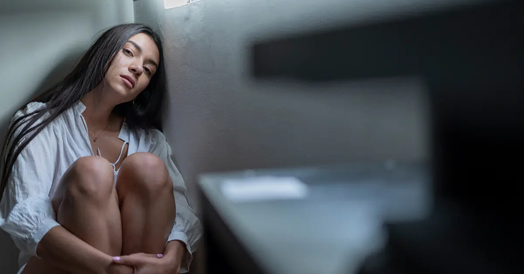 Woman crouched on the floor in a bathroom