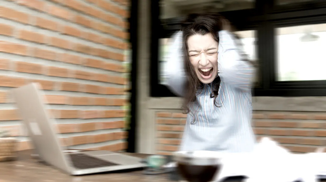 Woman loosing control while sitting at a desk