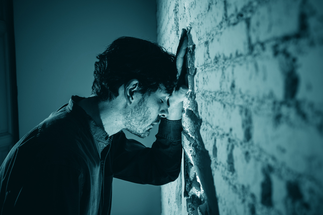Man touching a brick wall
