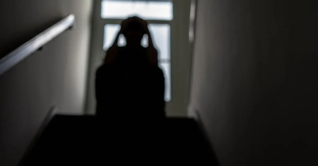 Silhouette of a person sitting on stairs