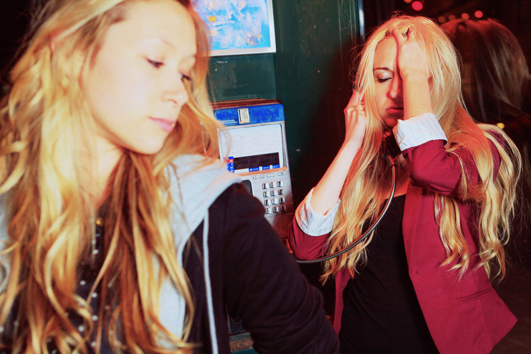 Two girls by a phone booth