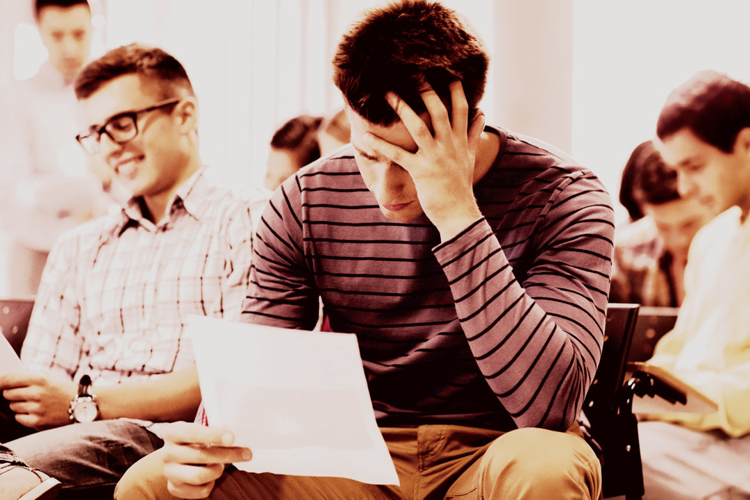 College student looking at papers, upset