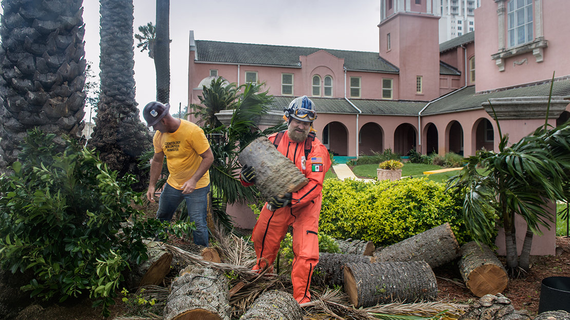 Ms and Los Topos saw up and remove uprooted trees at Peace Memorial Presbyterian Church.