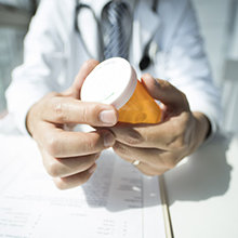 A doctor holding a pill bottle
