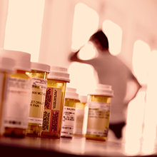 Man in front of different prescription pills