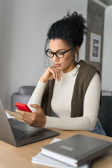 Woman looking at her phone at her desk