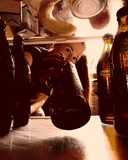 Woman taking beer from fridge