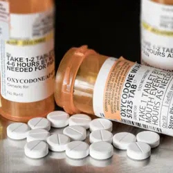 Bottles of Oxycodone with tables in foreground