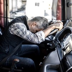 A truck driver sleeping on his steering wheel