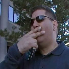 Marc Headley in blue shirt, glasses, smoking