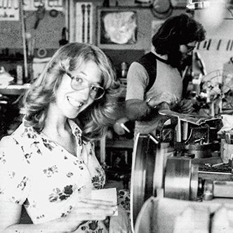 Janet Deering sanding a pot on a spinning lathe