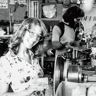 Janet Deering sanding a pot on a spinning lathe
