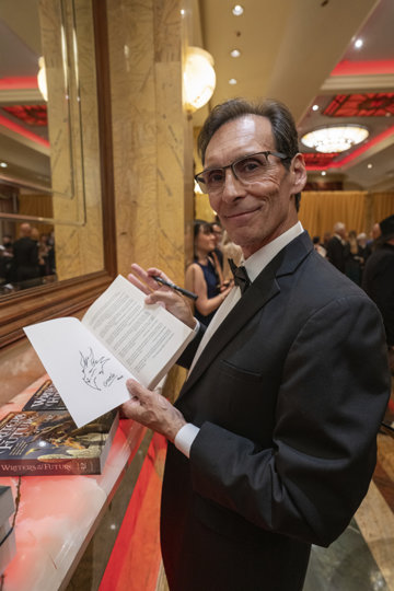 Acclaimed fantasy artist Ciruelo Cabral holding the Writers of the Future book.