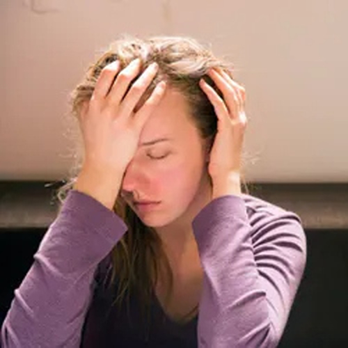 Drowsy woman holding her head