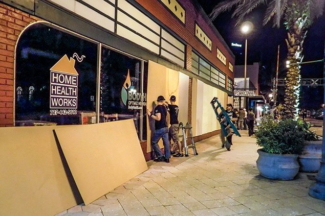 Clearwater. Scientology Volunteer Ministers putting boards on storefront