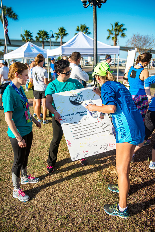 Runners converge at the 28th Annual Say No to Drugs Holiday Classic Race, where Drug-Free World distributes educational materials.