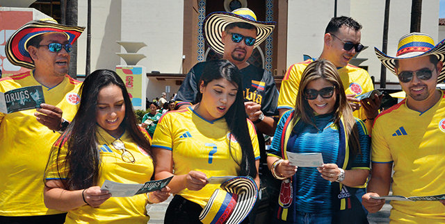 A DFW volunteer distributes booklets to fans near the Angel of Independence monument in Mexico City (left). Colombian fans receive booklets in Los Angeles—one of the 16 World Cup host cities where DFW teams got the message out.