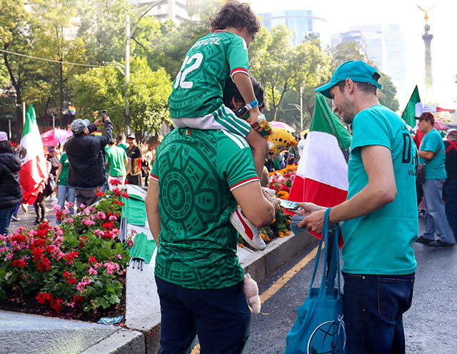 A DFW volunteer distributes booklets to fans near the Angel of Independence monument in Mexico City (left). Colombian fans receive booklets in Los Angeles—one of the 16 World Cup host cities where DFW teams got the message out.