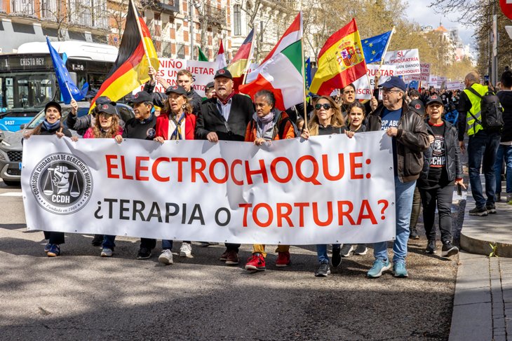 CCHR demonstration march in Madrid with large anti-psychiatry banner.