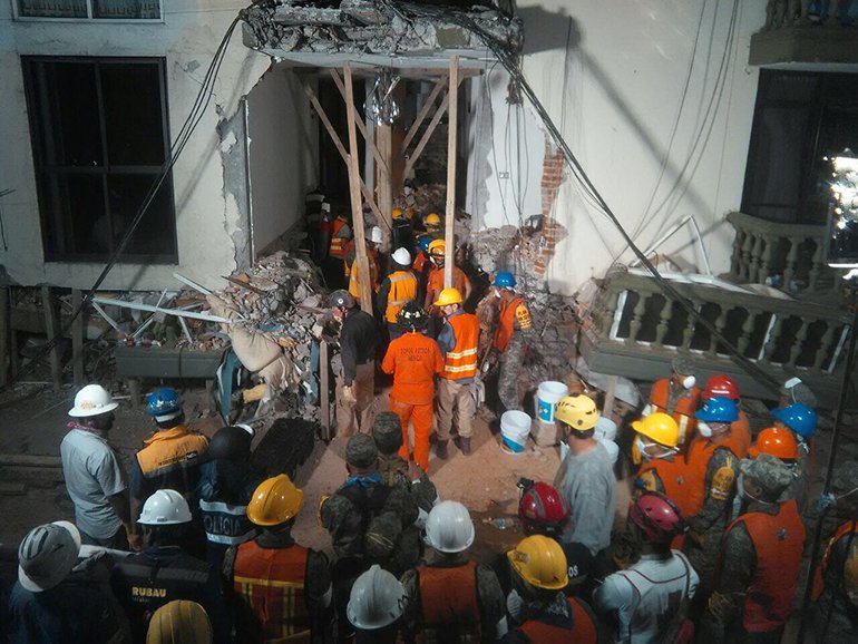 Rescue workers stand by to help at Enrique Rebsamen School, waiting for word about Paulina Gomez, one of the children trapped under the rubble.