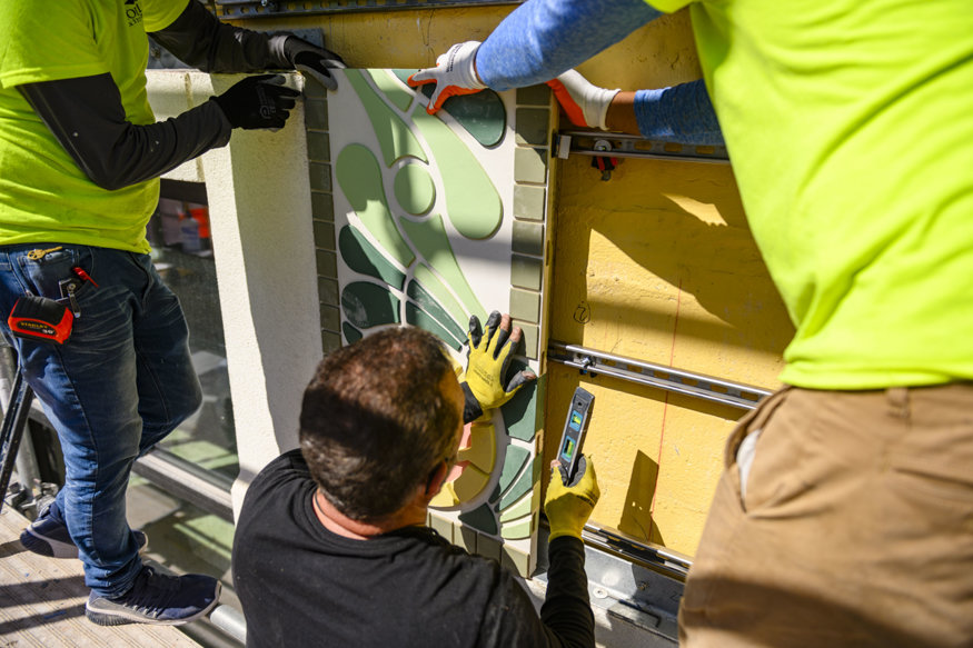 Tiles being aligned with a level on building façade.