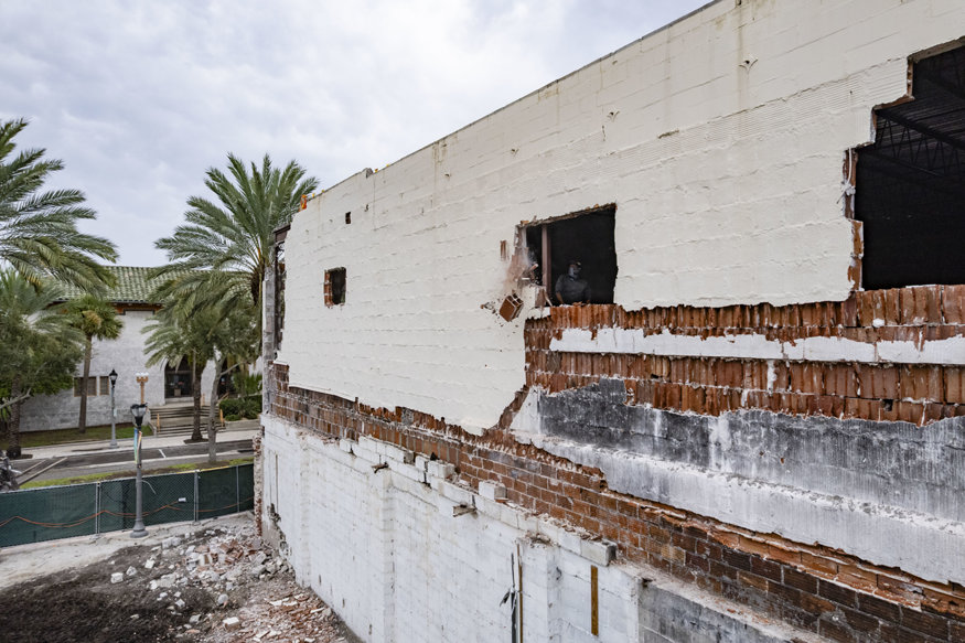 Worker manually demolishes masonry wall at 639 Cleveland Street.