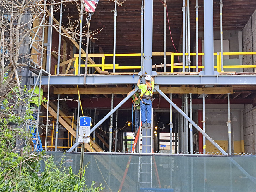 Construction crew installing and welding steel columns to strengthen the historic Telephone Building.