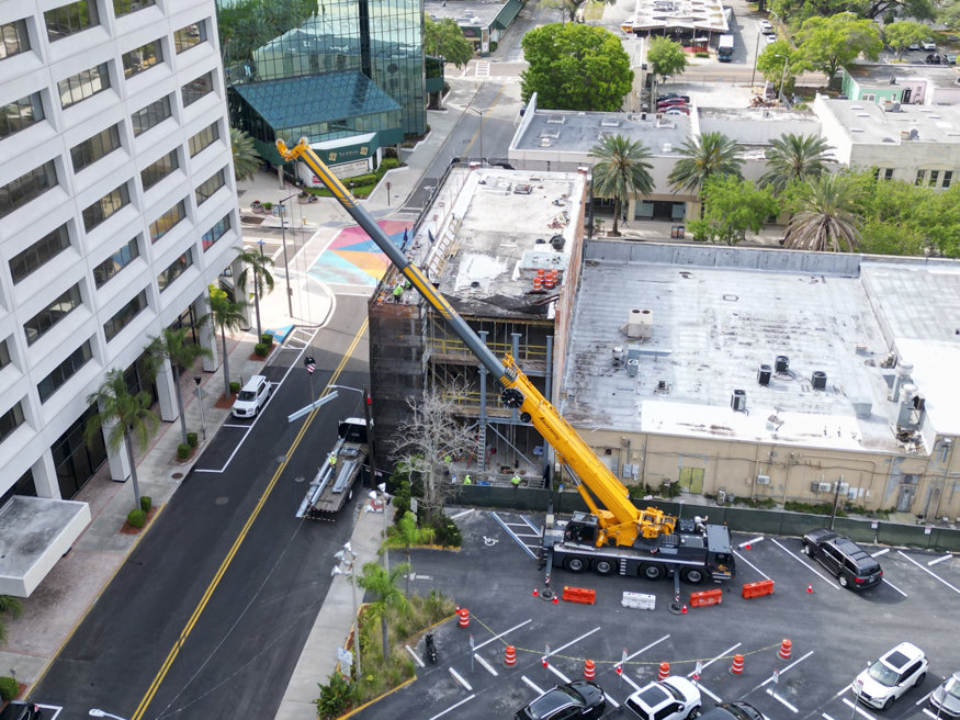 Aerial view of the Telephone Building with a yellow crane installing structural steel columns to strengthen the historic structure.
