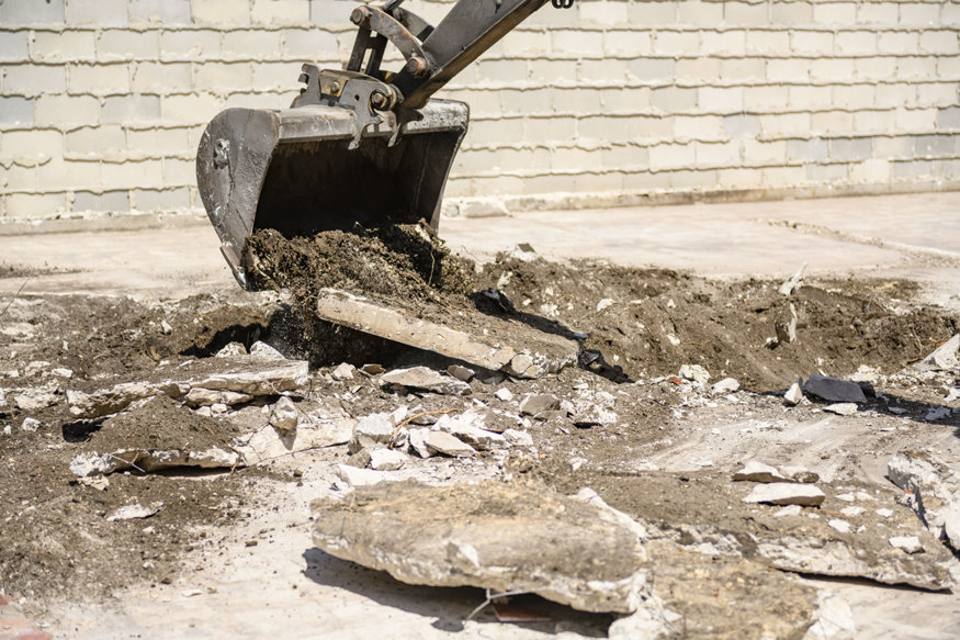 Excavator clearing debris during site preparation at 635 Cleveland Street.