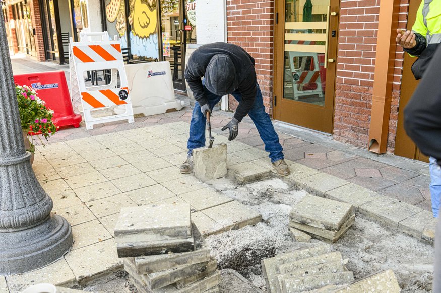 Lifting sidewalk pavers.