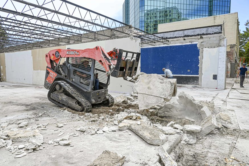 Loader moves concrete debris from storefront area.