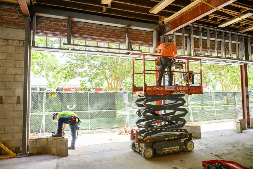 Crew members installing metal soffit frames at the Woolworth storefront