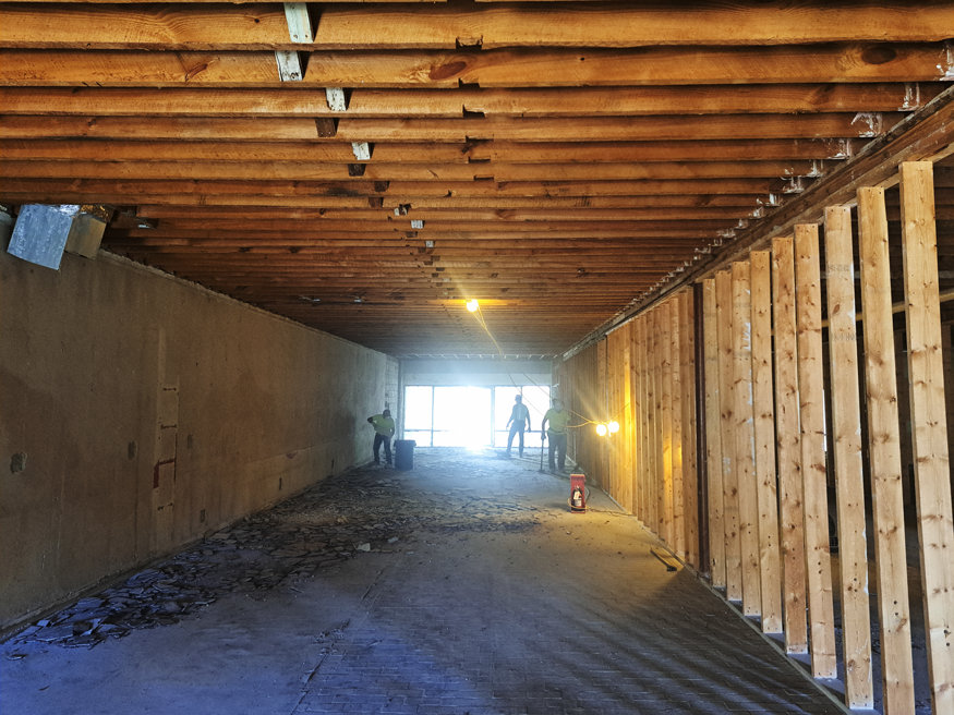 Interior demolition progresses at 623 Cleveland Street, with exposed framing and ceiling joists visible as workers clear debris from the space.