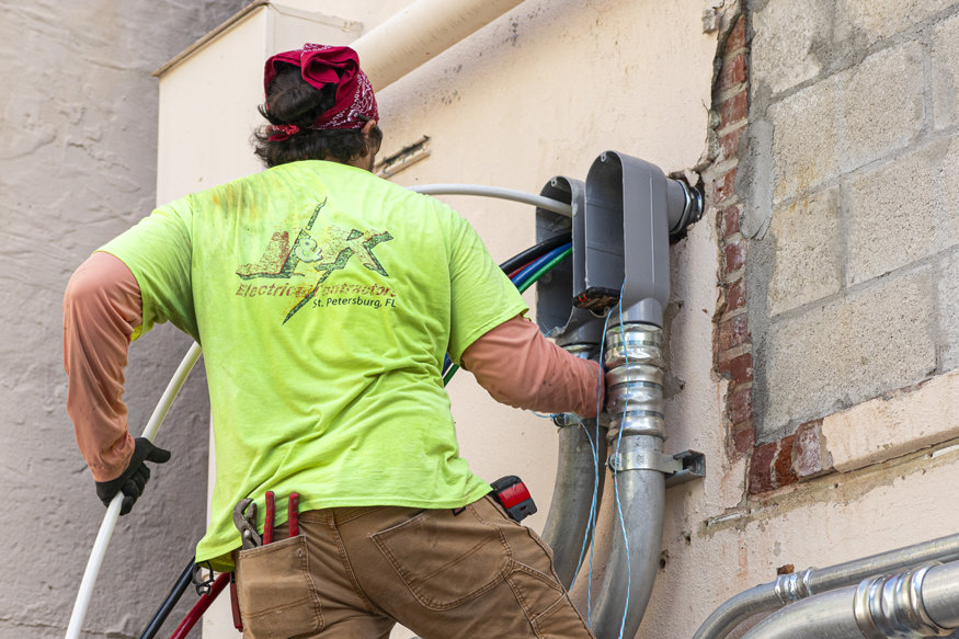 Electricians working at rear service panel