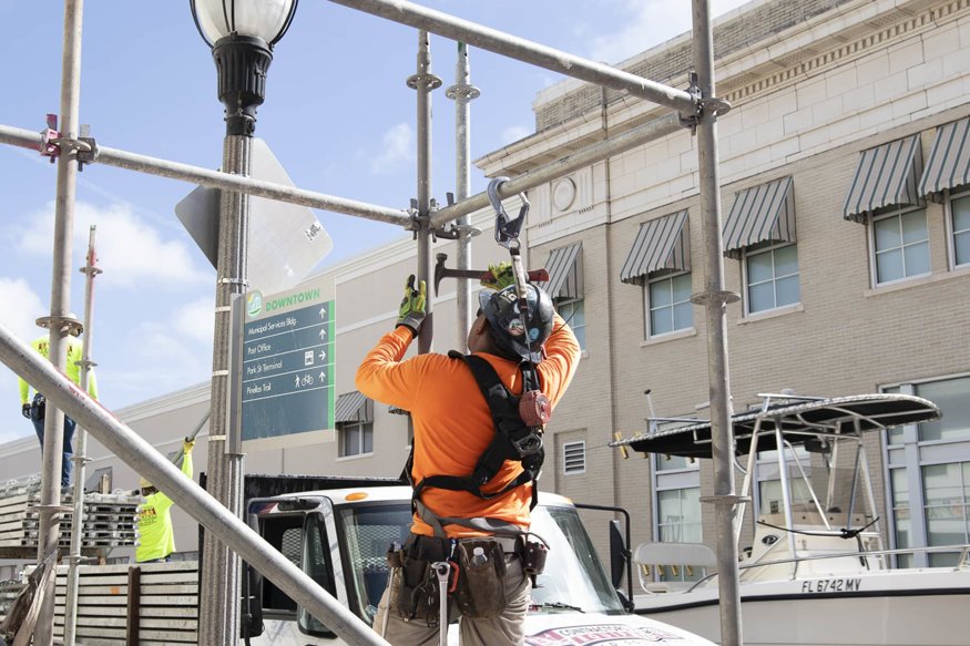 Worker taking apart scaffolding structure.