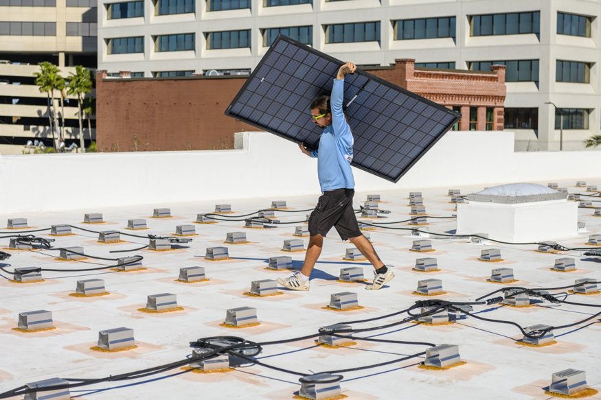 Solar panels are placed on the mounting brackets on the rooftop.