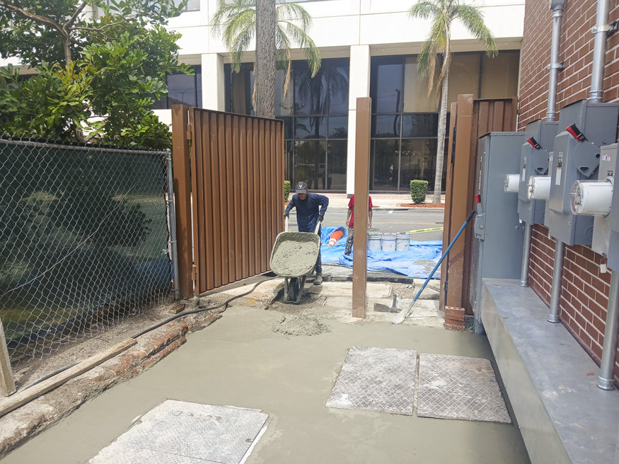 Crew members wheel in the fresh concrete.