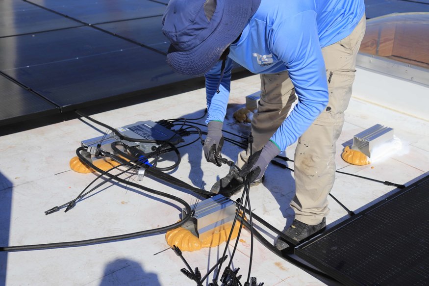 Wiring connections are made between solar panels and microinverters.