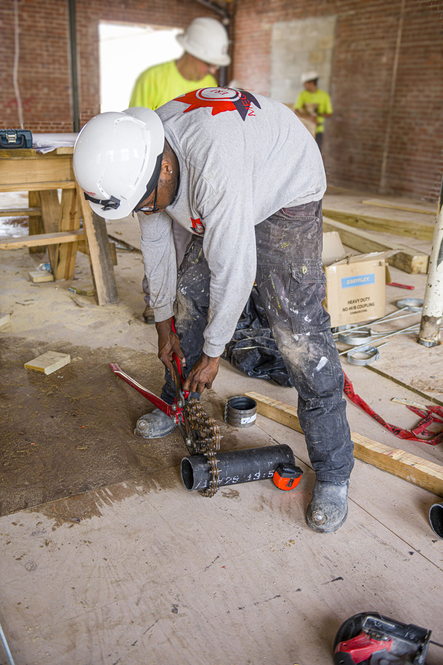 Piping being cut for rough-in installation at Peoples Bank.