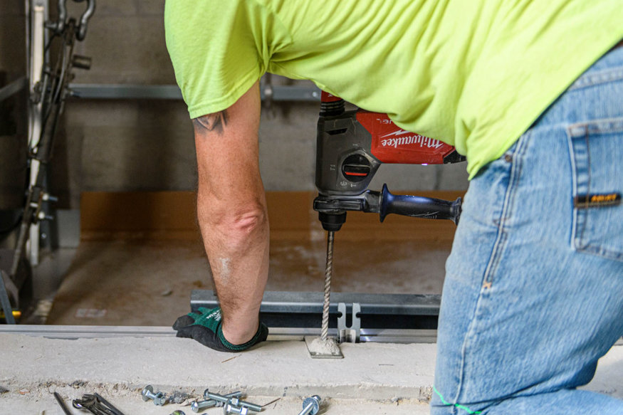Crew members secure elevator parts to the building.