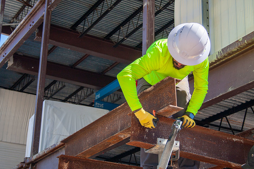 Worker loosens connection on temporary steel shoring.