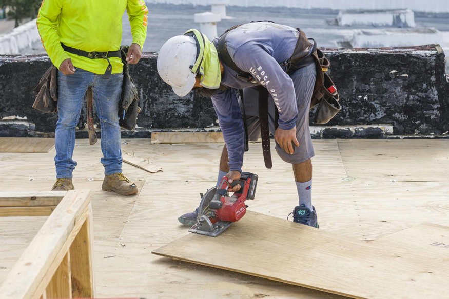 Workers are cutting fresh wood for the skylight frame