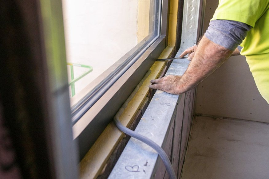 Insulation is added around the glass to seal the opening and protect the interior.