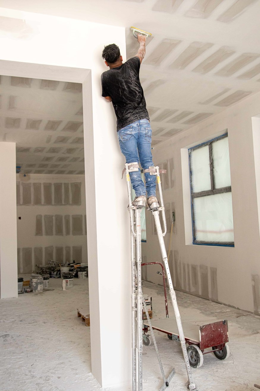 Crew sanding drywall ceilings and walls. 
