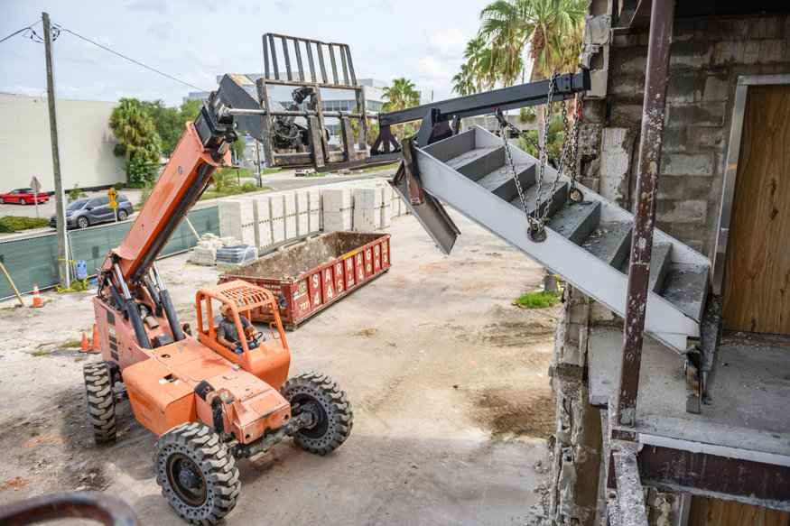Heavy equipment lifts steel stair flight at 639 Cleveland Street.